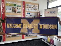 Welcome Charles Woodson custom banner holding by two people inside the store