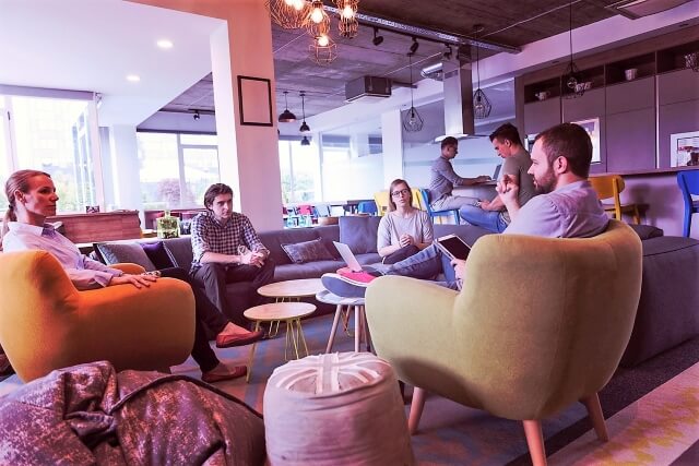 a group of employees sit together in a lounge area