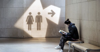 a wayfinding sign uses shadows to indicate the bathrooms