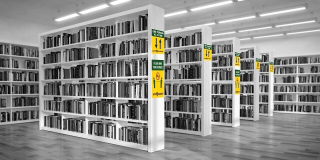 a library has signage on the bookcases