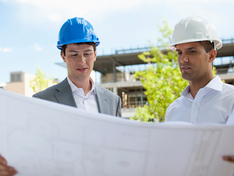 two men wearing hardhards on a construction site