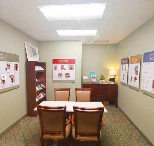 Room with different frames on the wall with tables and chairs