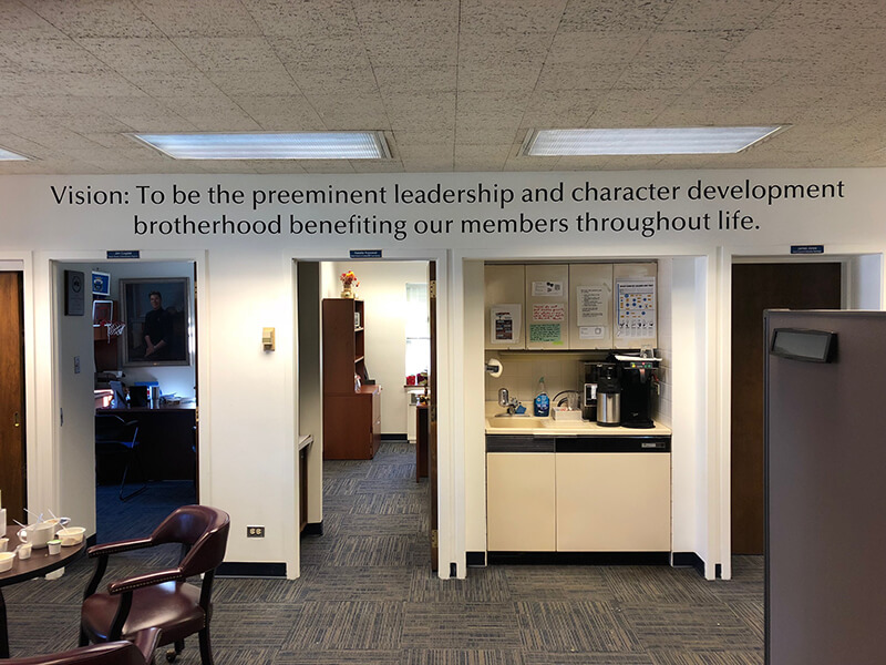Room with Vision word in the wall with chairs refrigerator and furniture
