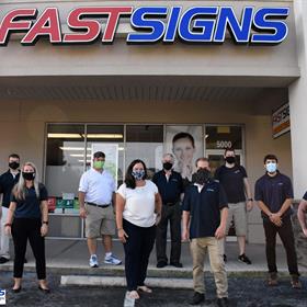 the team at FASTSIGNS of central Orlando stand outside the storefront