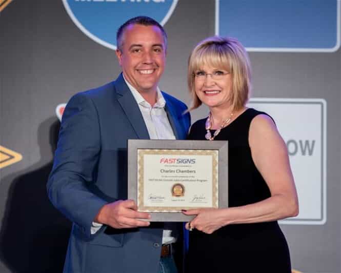 Charles Chambers and Catherine Monson with the Certified FASTSIGNS Sales Executive award