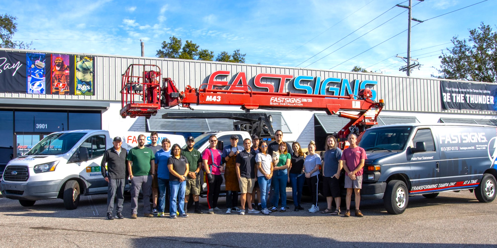 The team at FASTSIGNS South Tampa poses outside their storefront