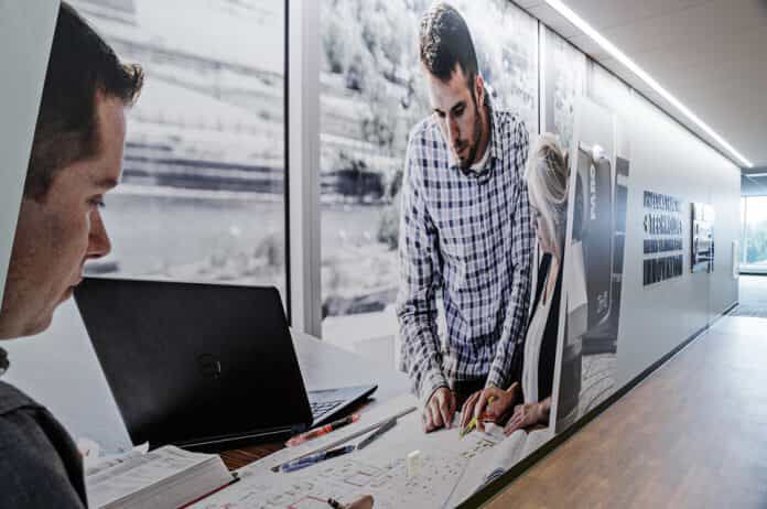 a wall mural showing people working with a laptop