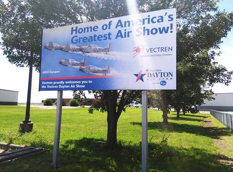 Vectren Dayton Air show banner on a lot with trees and grass