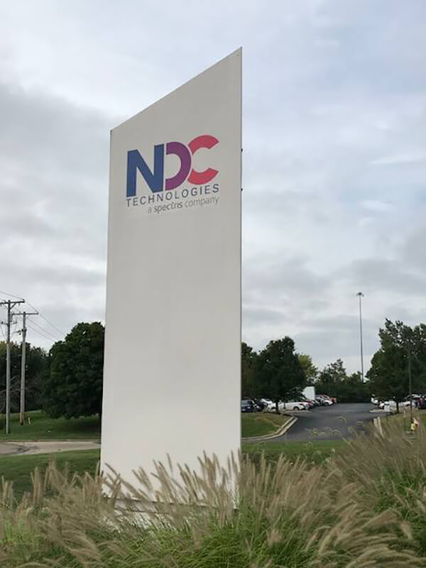NDC exterior signage on the side of the road surrounded by plants