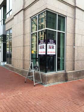 a window sign hangs on the corner of a building