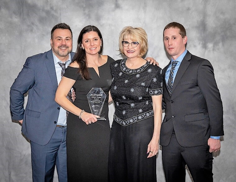 FASTSIGNS of Manchester celebrates being a top-performing center. Franchisee Joel Miller (far left), Krissy Sullivan (2nd from left), Catherine Monson (2nd from right), CEO of Propelled Brands, the multi-brand platform company of FASTSIGNS, and William Arcari (far right)