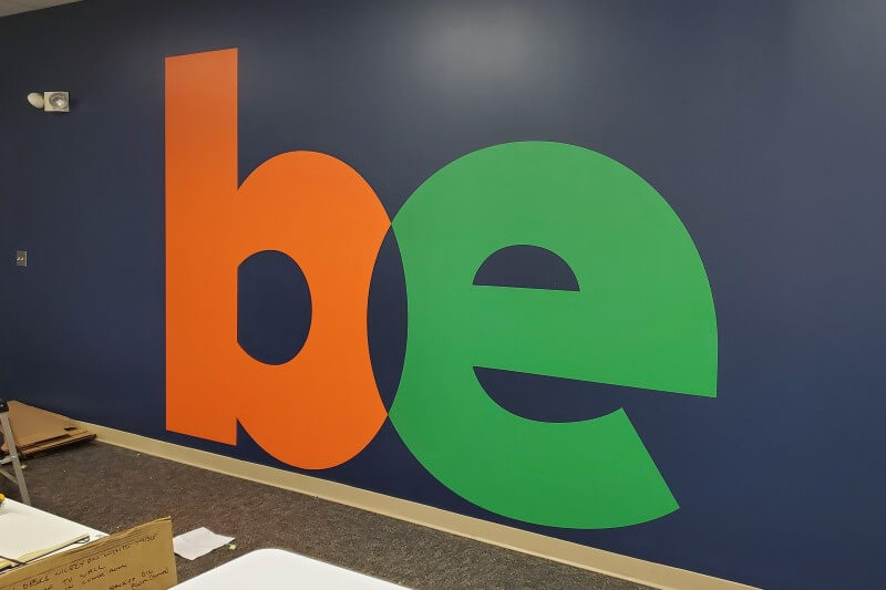 Be custom decal on a colorful wall