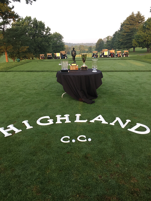Highland C.C. word on the grass with black table and trophies