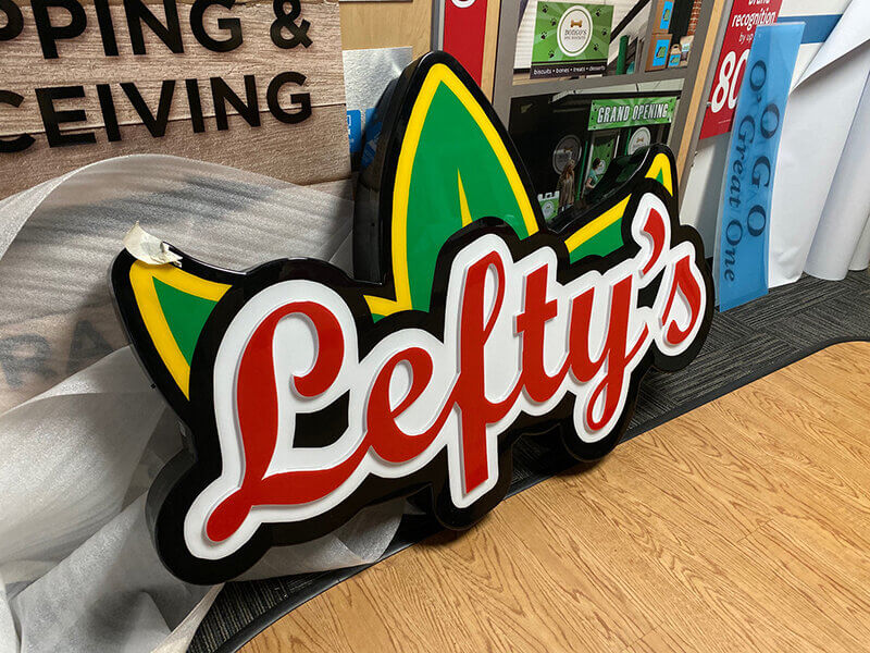 Lefty's custom sign with leaf background place on wood floor