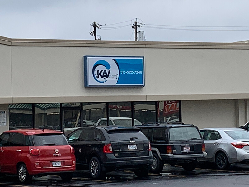 KAV blue and white signage on the building with cars and electricity pole in the background