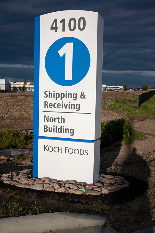 Koch Foods entrance signage on the rocks with a man shadow