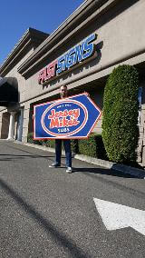 Man holding as Jersey Mikes signage in front of the fast sign office