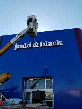 Jude & black signage  on the building with crane truck