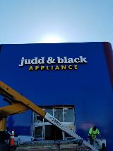 Finish Jude & Black Appliance signage on the building with crane truck