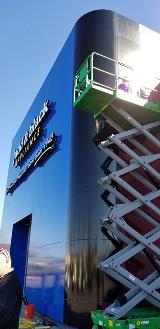 Blue building with signage and crane lift 