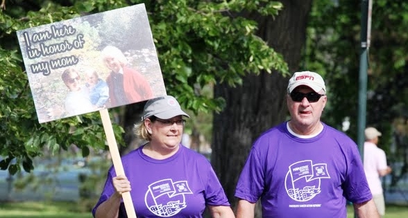 a purple stride walker holds a sign in honor of her mom