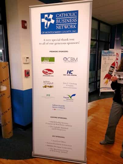 A retractable banner used for Catholic Business network sponsors