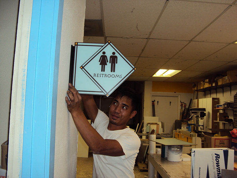 Restroom sign holding by an employee