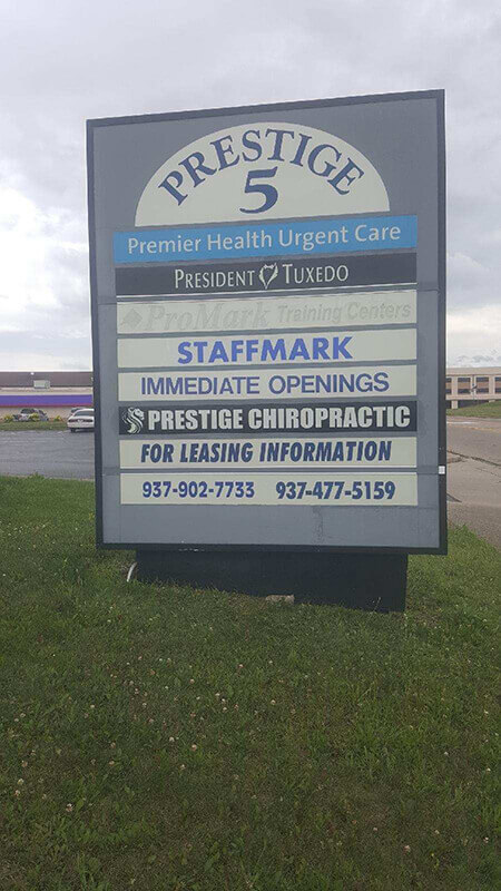 Prestige 5 Wayfind Signs by the side of the road with car and building on the back