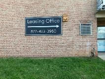 Leasing office wayfinding sign on the brick wall