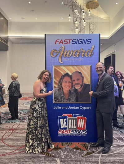 An image of Jolie and Jordan Cypert next to an award banner.