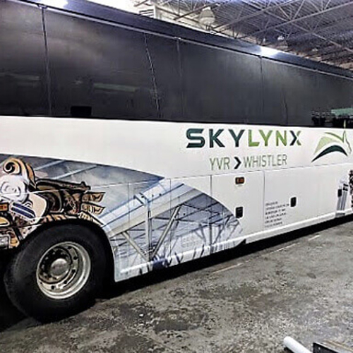 White bus with custom vehicle wrap