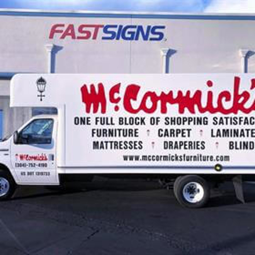 Mc cormick white van with letterings in front of fast sign building