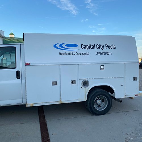 White truck with lettering of capitol city pools