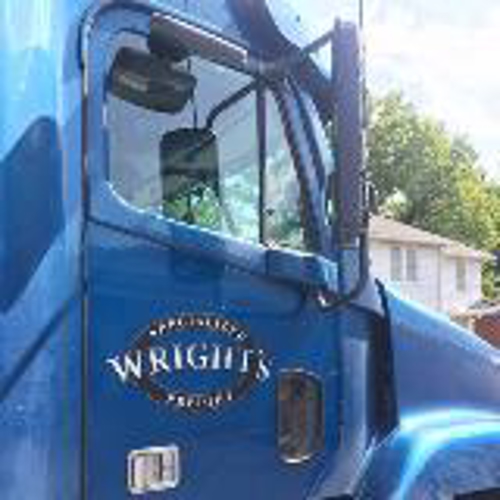 Blue truck with wright freight logo parked on side