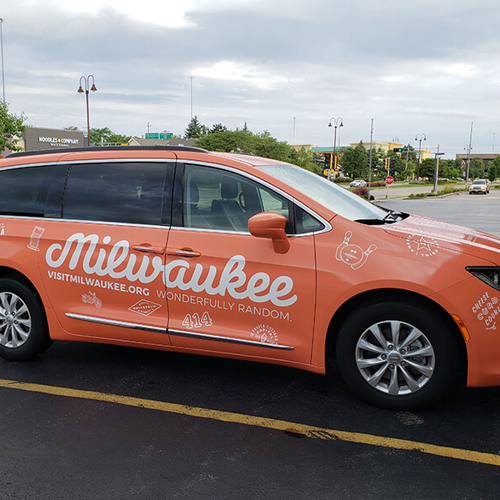Orange car with Milwaukee graphics parked outside the office